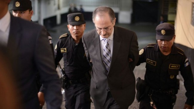 El ex diputado Pedro Muadi Menéndez en sus día de desgracia, saliendo de la Torre de Tribunales engrilletado y custodiado por varios agentes de la Policía Nacional Civil, después de haberse entregado a la justicia para ser enjuiciado.